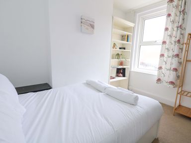 A bedroom with a bed and shelf at Weymouth Seaside House in Weymouth