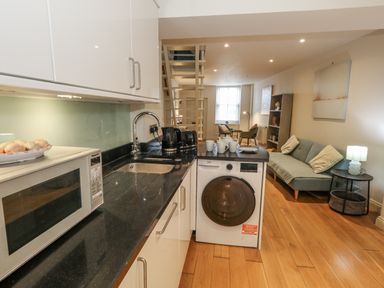 A kitchen with a washing machine and a microwave at Harbourside in Weymouth