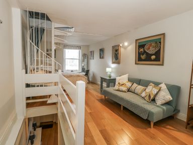 A living room with a sofa and stairs at Harbourside in Weymouth