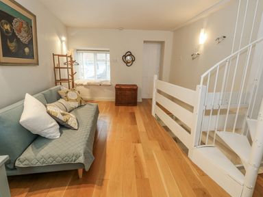 A living room with a sofa and staircase at Harbourside in Weymouth