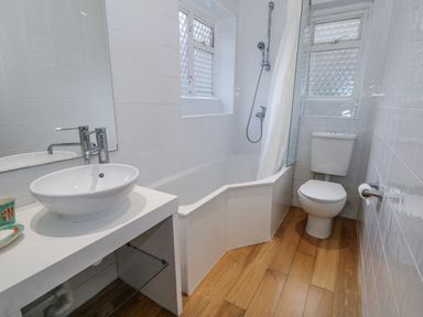 A bathroom with a sink, tub, shower, and toilet at Harbourside in Weymouth