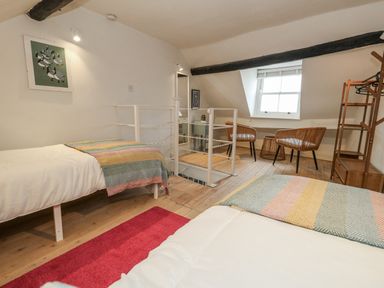 A bedroom with two beds and seating area at Harbourside in Weymouth