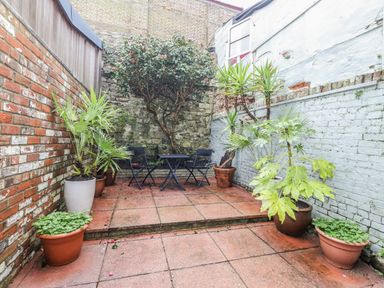 A garden area with potted plants and a patio table at Harbourside Weymouth
