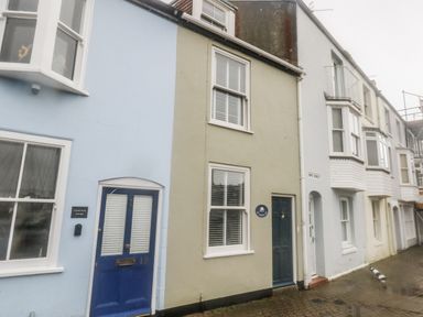 A row of houses with blue and green exteriors at Harbourside in Weymouth