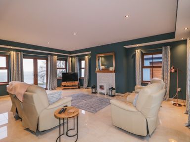 A living room with a television and a sofa at Ard Na Mara in Drung near Quigley's Point, County Donegal