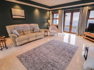 A living room with a sofa and television at Ard Na Mara in Drung near Quigley's Point, County Donegal