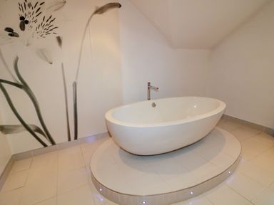 A bathroom with a freestanding bathtub and wall mural at Ard Na Mara in Drung near Quigley's Point, County Donegal