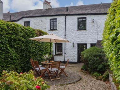 A garden with a table and chairs at 2 New Mill Cottages North Bovey