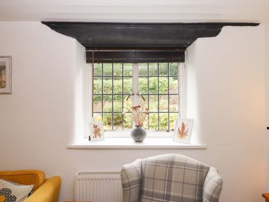 A living room with a window and decorative items at 2 New Mill Cottages North Bovey