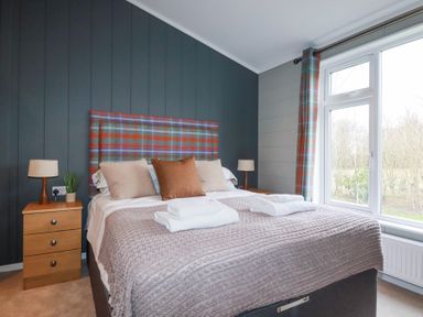 A bedroom with a bed and bedside tables with lamps at 6 Meadow Retreat in Dobwalls