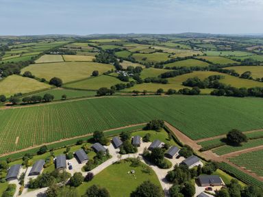 An aerial view of fields and houses at 6 Meadow Retreat in Dobwalls