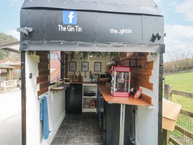 A small outdoor mobile bar with wooden counters and a popcorn machine at Bell tent 4 in Camerton near Timsbury