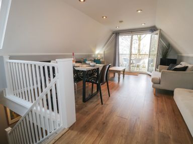 A living room with sofas dining table chairs and sliding doors leading to a balcony at Valley Lodge 38 in St Anns Chapel Cornwall