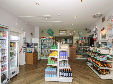 A small convenience store with shelves stocked with drinks snacks and toys at Valley Lodge 38 in St Ann's Chapel Cornwall