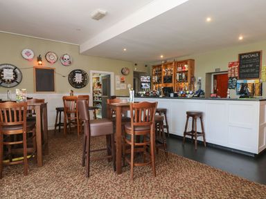 A bar area with wooden stools and tables darts on the wall and a specials board at Valley Lodge 38 in St Anns Chapel Cornwall