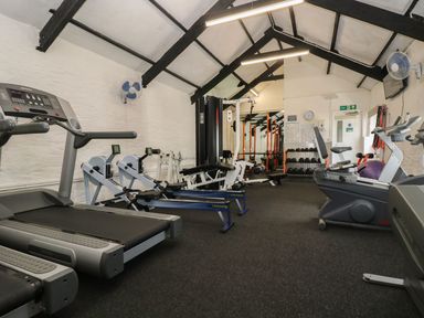 A gym with treadmills rowing machines exercise bikes weight racks and fitness equipment at Valley Lodge 38 St Ann's Chapel Cornwall