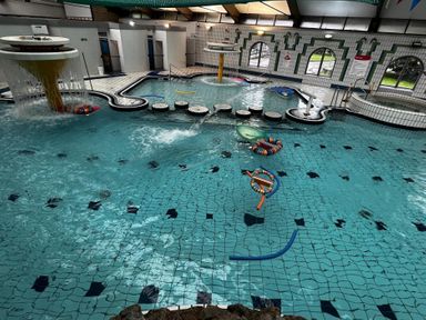 A swimming pool with a water slide and floating toys at Valley Lodge 38, St Ann's Chapel, Cornwall
