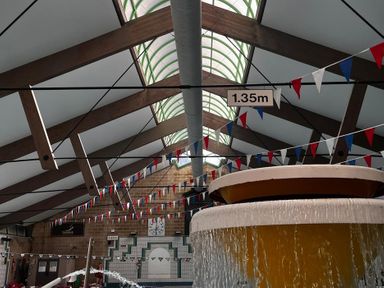 An indoor pool area with a fountain and bunting at Valley Lodge 38 St Ann's Chapel, Cornwall