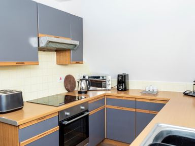 A kitchen with gray cabinets wooden countertops a toaster kettle coffee maker and oven at Valley Lodge 40 in St Ann's Chapel Cornwall