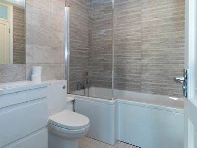 A bathroom with a toilet sink and bathtub with tiled walls at Valley Lodge 3 St Ann's Chapel Cornwall