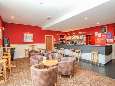 A bar area with stools a counter and seating with tables and chairs at Valley Lodge 3 in St Ann's Chapel Cornwall