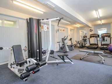 A gym room with exercise machines including treadmills stationary bikes and weight benches at Valley Lodge 3 St Ann's Chapel Cornwall
