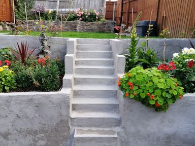 A garden with stairs and flower beds at Colliers Cottage in Cinderford
