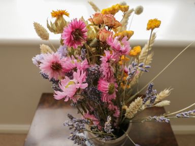 A bouquet of dried flowers with pink purple and yellow blooms on a wooden table at South Barn Cottage in Hatford near Stanford In The Vale