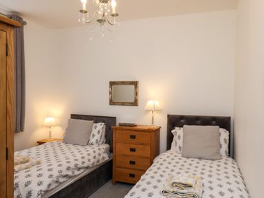 A bedroom with two single beds and a wooden dresser between them at The Bungalow in Whitby
