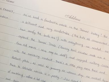 A handwritten note about a week spent in the Tamar Valley on lined paper on a wooden surface at Tamar Cottages 35 St Ann's Chapel Cornwall