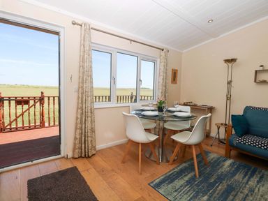 A dining room with a table and chairs at Boa Vista in Bacton