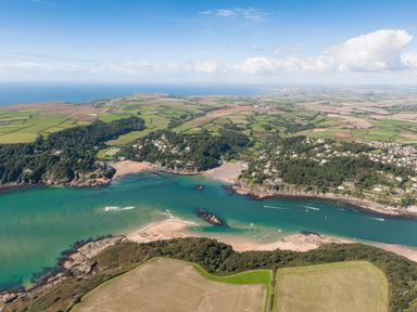 An aerial view of a coastal landscape with fields forests sandy beaches and houses at Moult Hill Barn in Salcombe