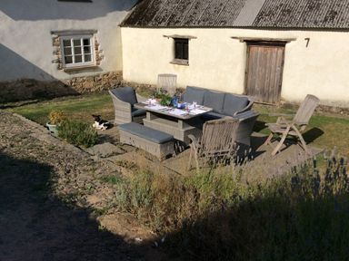 A garden with a table and chairs at Westacombe Farm in Dunsford near Tedburn St Mary