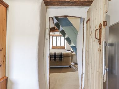 A view of a living room with a staircase at Westacombe Farm in Dunsford