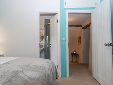 A bedroom with a bed and an adjoining bathroom at Westacombe Farm in Dunsford