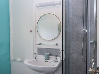 A bathroom with a sink, mirror, and shower at Westacombe Farm in Dunsford