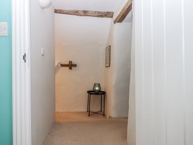 A hallway with a table and vase at Westacombe Farm in Dunsford