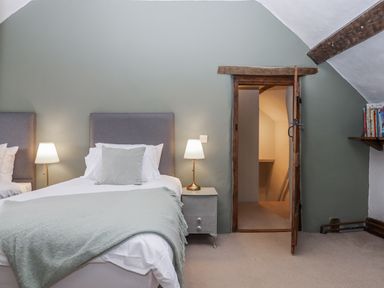 A bedroom with beds and a door at Westacombe Farm in Dunsford