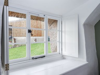 A room with a window showing grass and outdoor area at Westacombe Farm, Dunsford