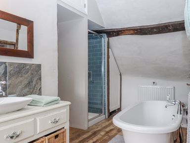 A bathroom with a bathtub and shower at Westacombe Farm in Dunsford