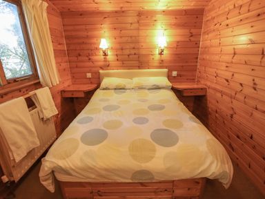 A bedroom with a double bed between two wall-mounted bedside tables and two wall lights at Pheasant Withern near Alford