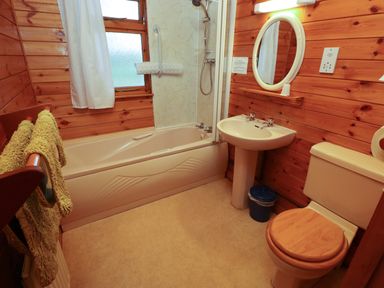 A bathroom with a bathtub shower sink toilet and towels at Pheasant in Withern near Alford