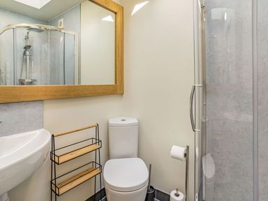 A bathroom with a toilet sink shower and mirror at Pant Y Cwtsh in Kidwelly