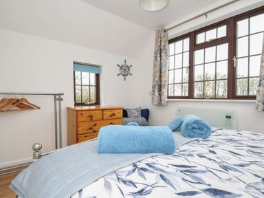 A bedroom with a bed and towels arranged on top at Kernyk in Camelford