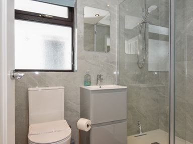 A bathroom featuring a toilet, sink, shower, and mirror at Kernyk in Camelford