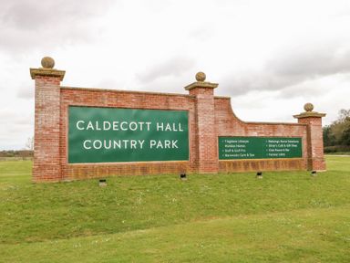 A brick entrance sign for Caldecott Hall Country Park on a grass lawn