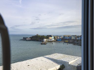 A coastal view of a harbor with boats and colorful buildings at No 10 Croft House in Tenby