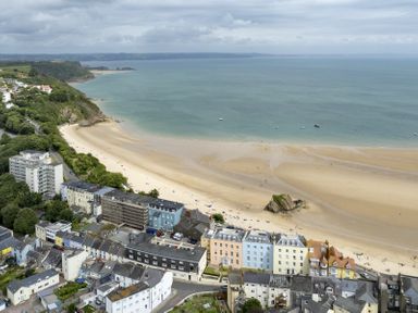 A coastal town with buildings along a sandy beach and the sea at No 10 Croft House in Tenby
