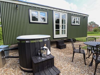 An outdoor area with a hot tub and seating table at Bluebell in Grimsby
