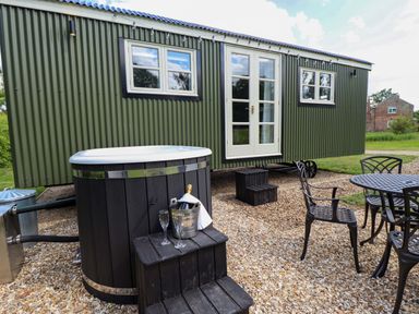 An outdoor area with a hot tub, table, and chairs at Primrose, Grimsby